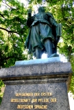 Bild: Fürst Ludwig, Schrift: „Dem Begründer der 1. Gesellschaft für Pflege der Deutschen Sprache Ludwig Fürst v. Anhalt-Coethen 1579-1650 Bildlegende: Denkmal beim Schloss Köthen © noten-apitz.de